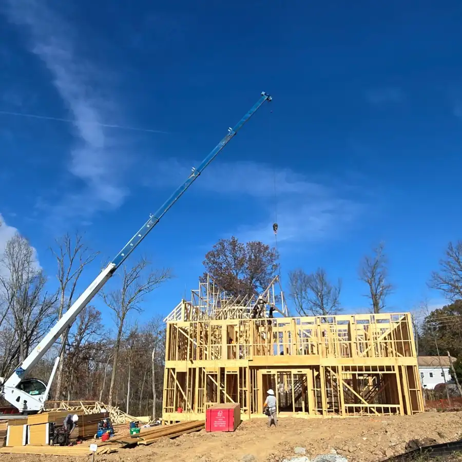 A crane setting framed walls on a new home